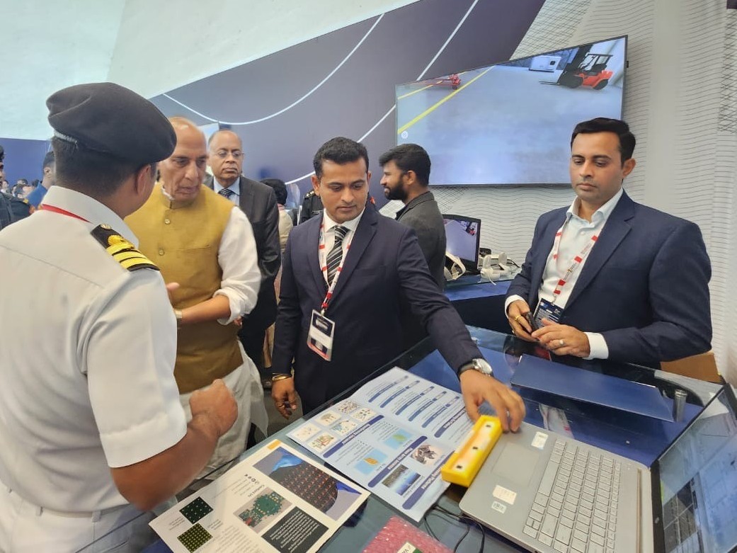 Siliconia team briefing a naval officer beside system displays and a hardware unit.